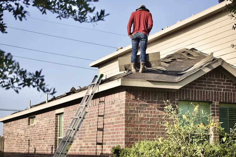 Professional roofer working on a residential roof in Transit Village